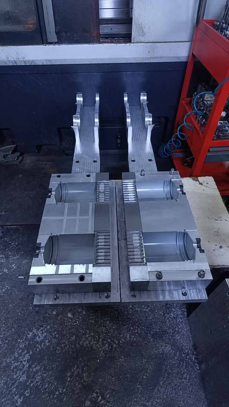 Şişe biçimli iki kalıp cebi ve uzun bağlantı kolları bulunan CNC işlenmiş metal kalıp