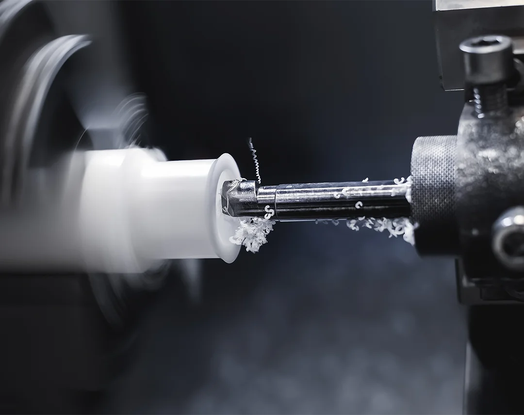 ARK CNC atölyesinde, bir CNC freze makinesinin PEEK mühendislik plastiği bloğu mikron hassasiyetinde işlemesi ve karmaşık teknik parça üretimi.